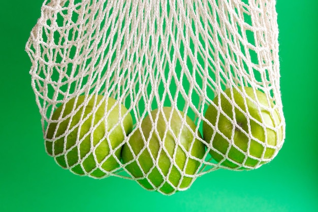 Maçãs verdes frescas em um saco de malha Alimentos saudáveis embalagens ecológicas Reciclagem de resíduos Zero desperdício