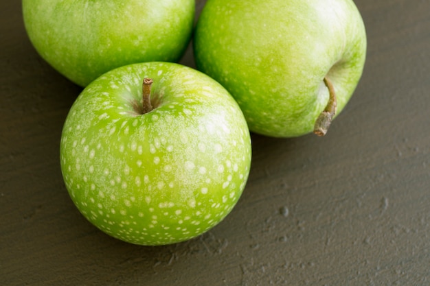 Maçãs verdes frescas na mesa, close-up.