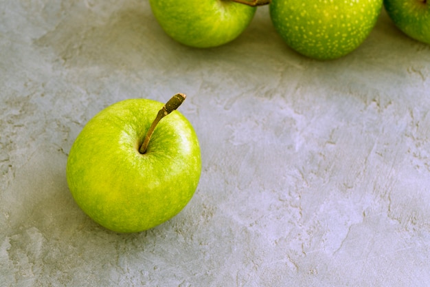 Maçãs verdes frescas na mesa, close-up.