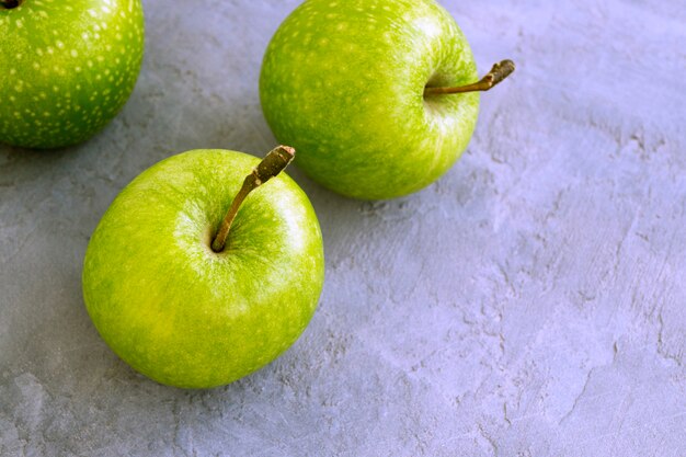 Maçãs verdes frescas na mesa, close-up.