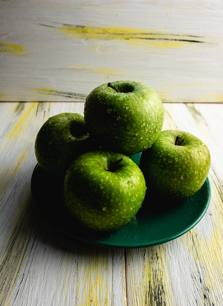 Maçãs verdes frescas na mesa de madeira velha. Comida saudável e ecológica. Harmonia de cores