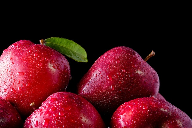 Maçãs vermelhas com folhas na mesa