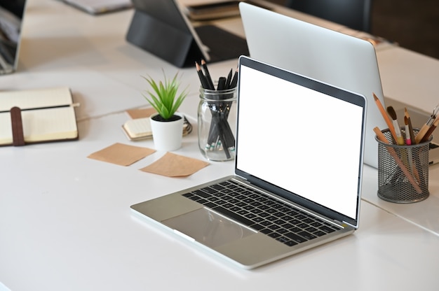 Macbook laptop com tela em branco na sala de reuniões criativas.