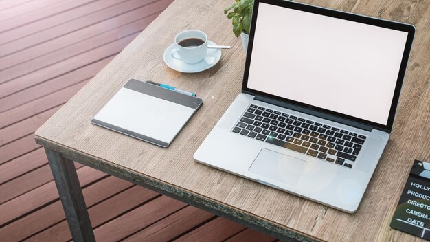 MacBook Pro ligado em cima da mesa de madeira marrom perto da xícara de chá com papel de parede de prato