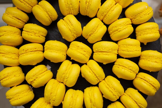 Maccarone de macaron amarelo de dar água na boca na vista superior bandeja cinza