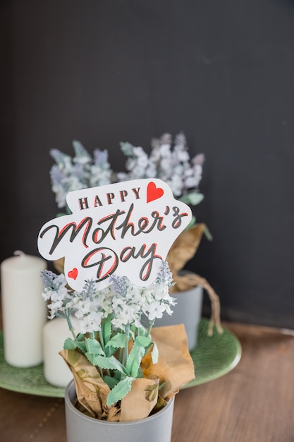 Maceta con texto, mensaje Feliz día de las madres en la mesa en el interior