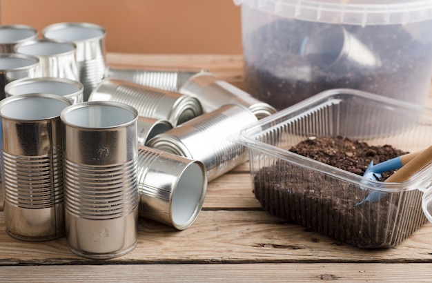 macetas recicladas para herramientas de jardinería en la mesa de trabajo