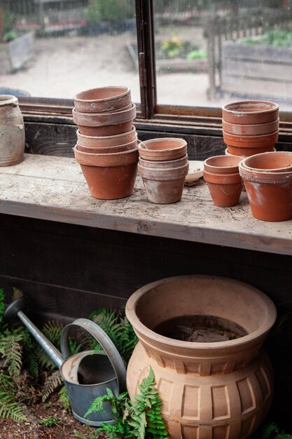 Macetas de terracota y regadera en la choza del jardinero