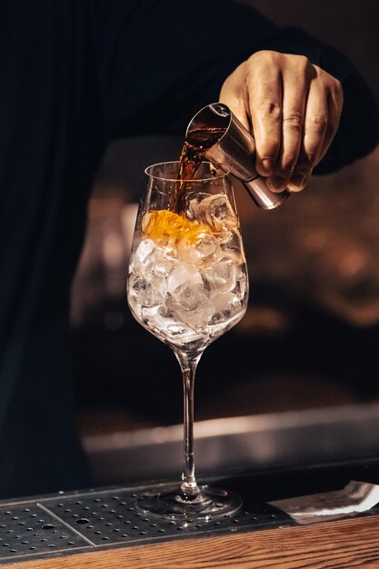 Machen Sie ein Cocktailglas mit Eis Step-by-Step-Cocktailherstellung Bartender's Job Orange Spirituosen