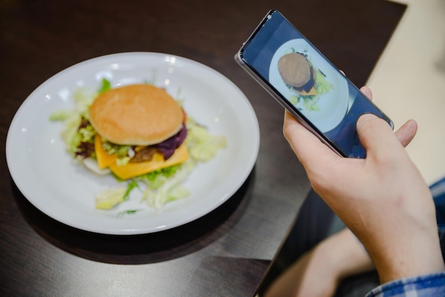 Machen Sie ein Foto von dem Fast Food auf dem Telefon