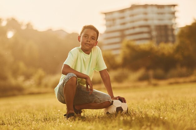 Machen Sie eine Pause mit Fußball afroamerikanische Kinder haben tagsüber im Sommer Spaß auf dem Feld