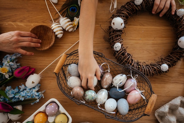 Machen Sie einen hausgemachten Osterkranz aus mit Eiern geschmückten Weinreben