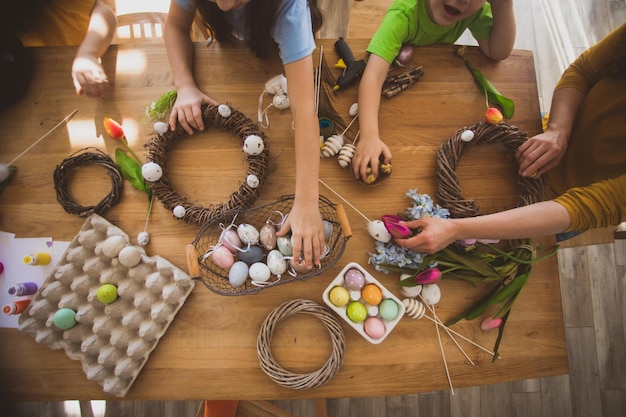 Machen Sie einen hausgemachten Osterkranz aus mit Eiern geschmückten Weinreben