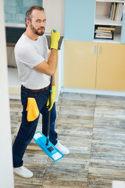 Machen Sie Ihr Haus sauber in voller Länge von einem professionellen männlichen Reiniger, der Handschuhe trägt