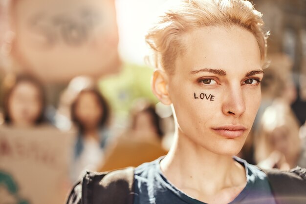 Machen Sie Liebe nicht Krieg Nahaufnahme Foto der jungen blonden Frau mit Wort Liebe geschrieben