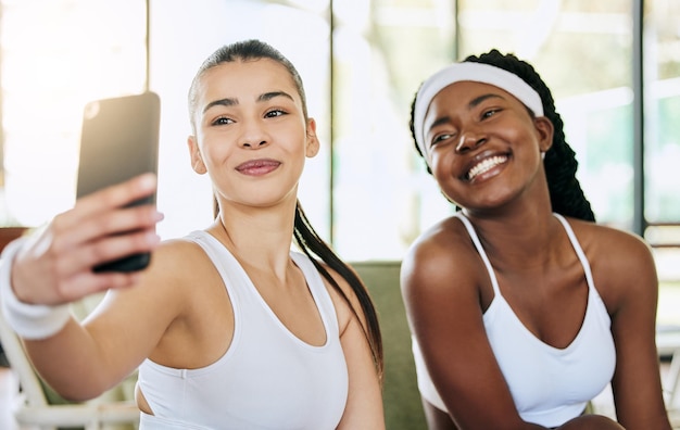 Machen Sie noch eine, nachdem wir unsere Trophäe abgeholt haben. Schnappschuss von zwei attraktiven jungen Tennisspielerinnen, die Selfies in ihrem Clubhaus machen