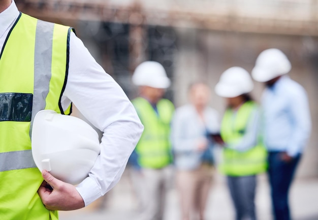 Machen Sie Sicherheit zur Priorität Aufnahme eines nicht wiederzuerkennenden Architekten mit Helm auf einer Baustelle