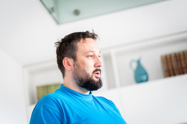 Macho adulto com retrato de barba sozinho dentro de casa