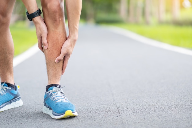 Macho adulto jovem com dor muscular durante a corrida