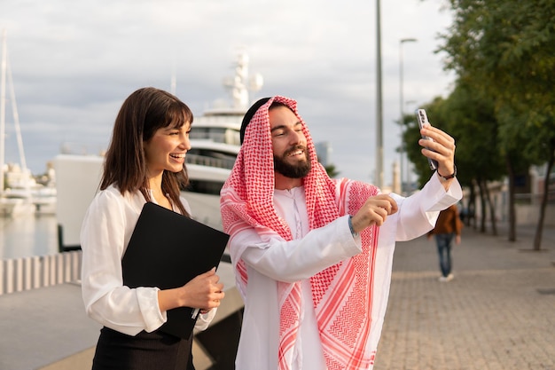 Macho árabe tomando selfie con empresaria