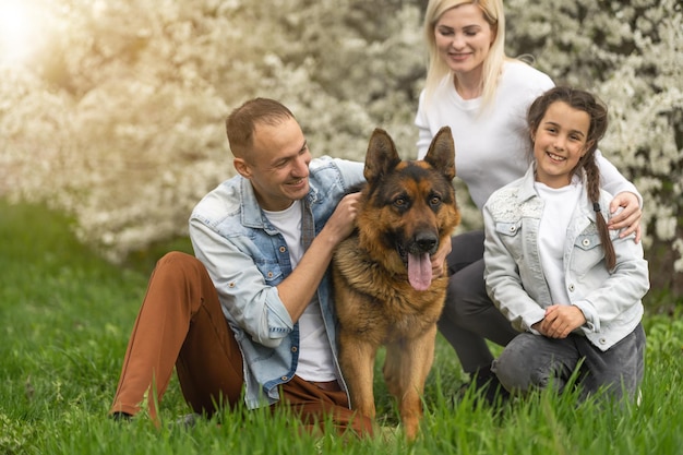 Foto macho e fêmea felizes brincando com a criança fora da primavera