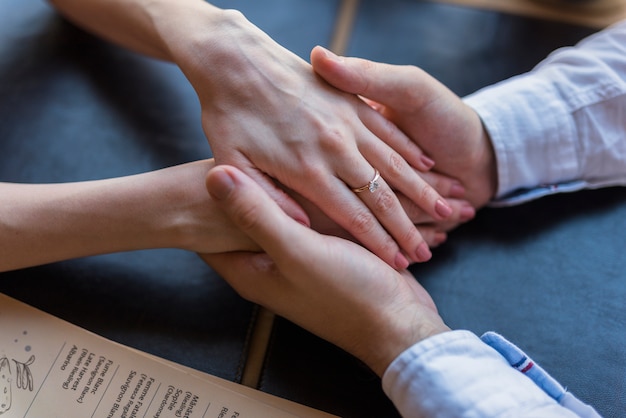 Foto macho y hembra que sostienen la mano en la mesa