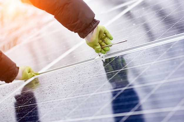 Macho instala baterias solares usando ferramentas em clima coberto de neve