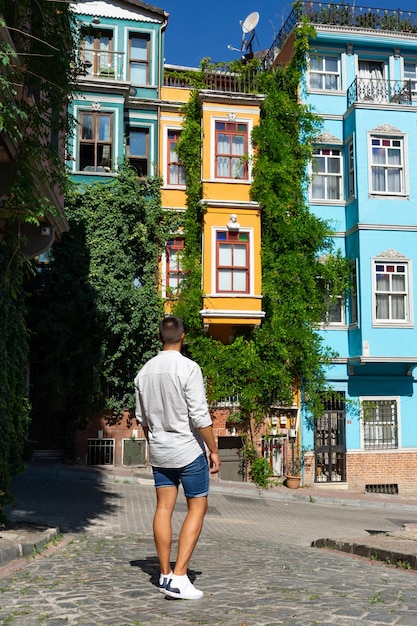 Macho jovem turista irreconhecível em uma rua de Istambul com edifícios coloridos