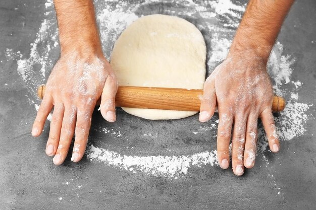 Foto macho mãos preparando massa para pizza na mesa closeup