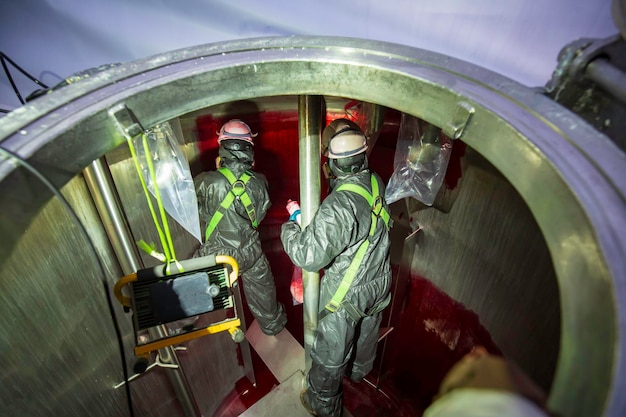 Macho na pintura de cor química do processo de inspeção de trabalho no espaço confinado do tanque de armazenamento de óleo