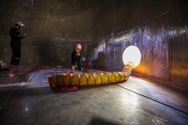 Macho no processo de inspeção de trabalho soprador de capô de tinta química de ar fresco no espaço confinado do tanque de armazenamento de óleo