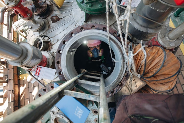 Macho en proceso de inspección de trabajo químico en tanque de acero inoxidable químico