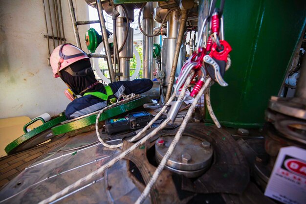 Macho en proceso de inspección de trabajo químico en tanque de acero inoxidable químico