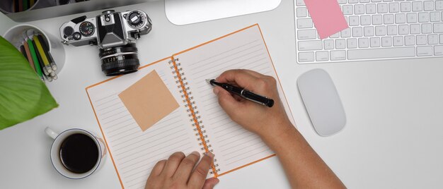 Macho tomando nota no caderno em branco na mesa de escritório