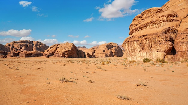 Macizos rocosos en el desierto de arena roja, cielo azul brillante en el fondo - paisaje típico en Wadi Rum, Jordania.