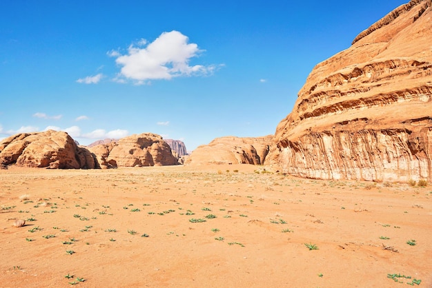 Macizos rocosos en el desierto de arena roja, cielo azul brillante en el fondo - paisaje típico en Wadi Rum, Jordania