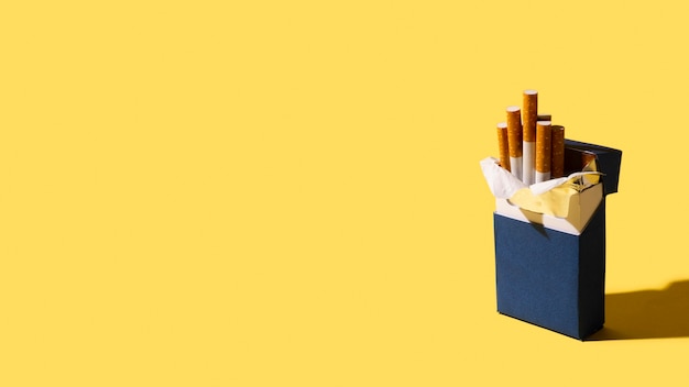 Maço de cigarros em fundo amarelo