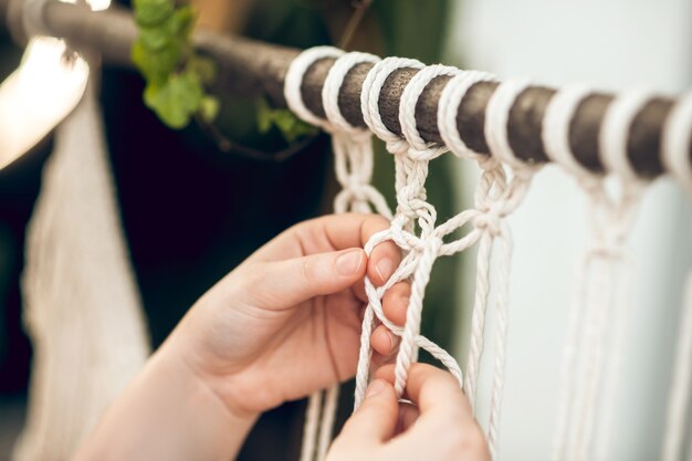 Macramé. Cerrar imagen de manos de mujer tejiendo macramé