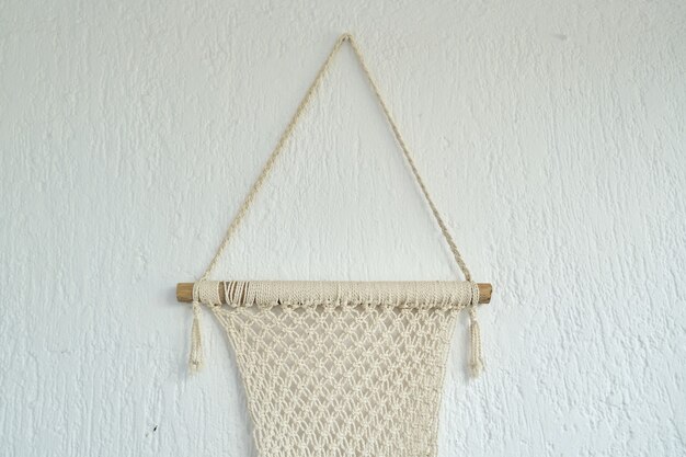 Macramé hecho a mano, panel decorativo tejido con cuerdas de algodón ligero en la pared.