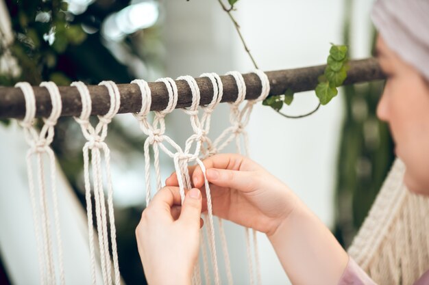 Macramé. imagem aproximada das mãos da mulher tecendo macramé