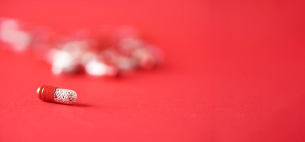 Foto macro de cápsulas rojas sobre fondo rojo. copia espacio montón de drogas, tratamiento para la gripe fría.