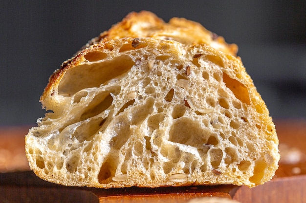 Macro do pão. Poros de pão. Baguete fresca com macro de grãos. Propaganda de padaria. Sementes no pão.