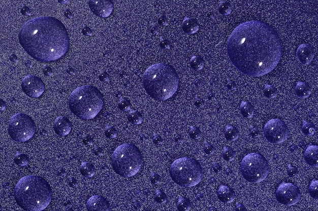 Macro de gotas de agua sobre fondo violeta