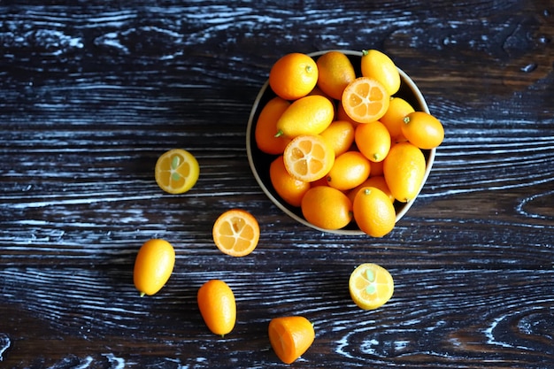 Macro. Kumquat em uma superfície de madeira. Frutas cítricas exóticas.