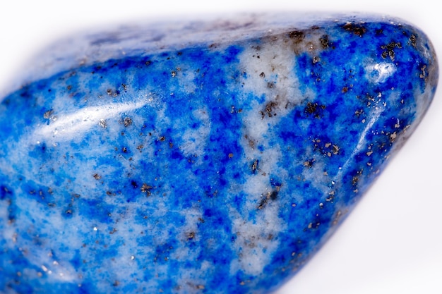 Macro mineral piedra azul lapislázuli afganistán sobre fondo blanco.