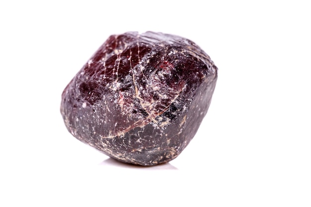 Macro de una piedra granate mineral sobre un fondo blanco.