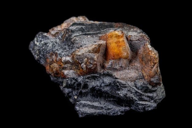 Macro de la piedra mineral Columbite Beryl Feldspar sobre un fondo negro