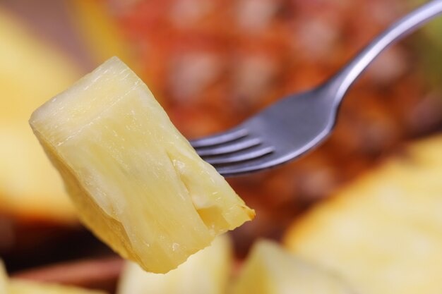 Macro de piña en rodajas con tenedor