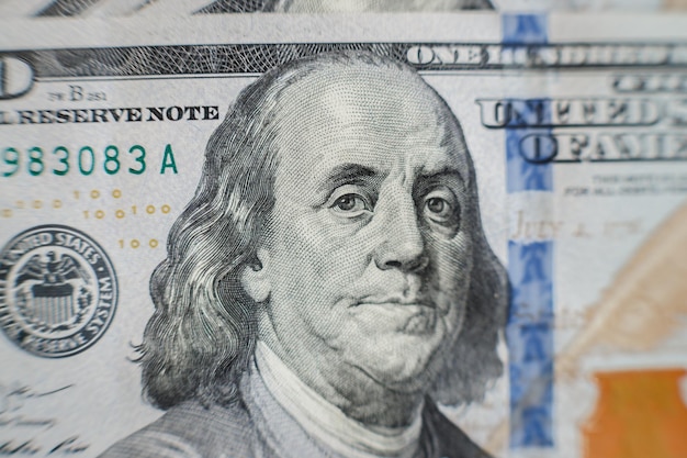 Macro primer plano de la cara de Ben Franklin en el billete de cien dólares estadounidenses