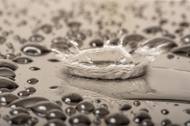 Macro salpicadura macro foto de una gota de agua que cae sobre una superficie reflectante enfoque selectivo